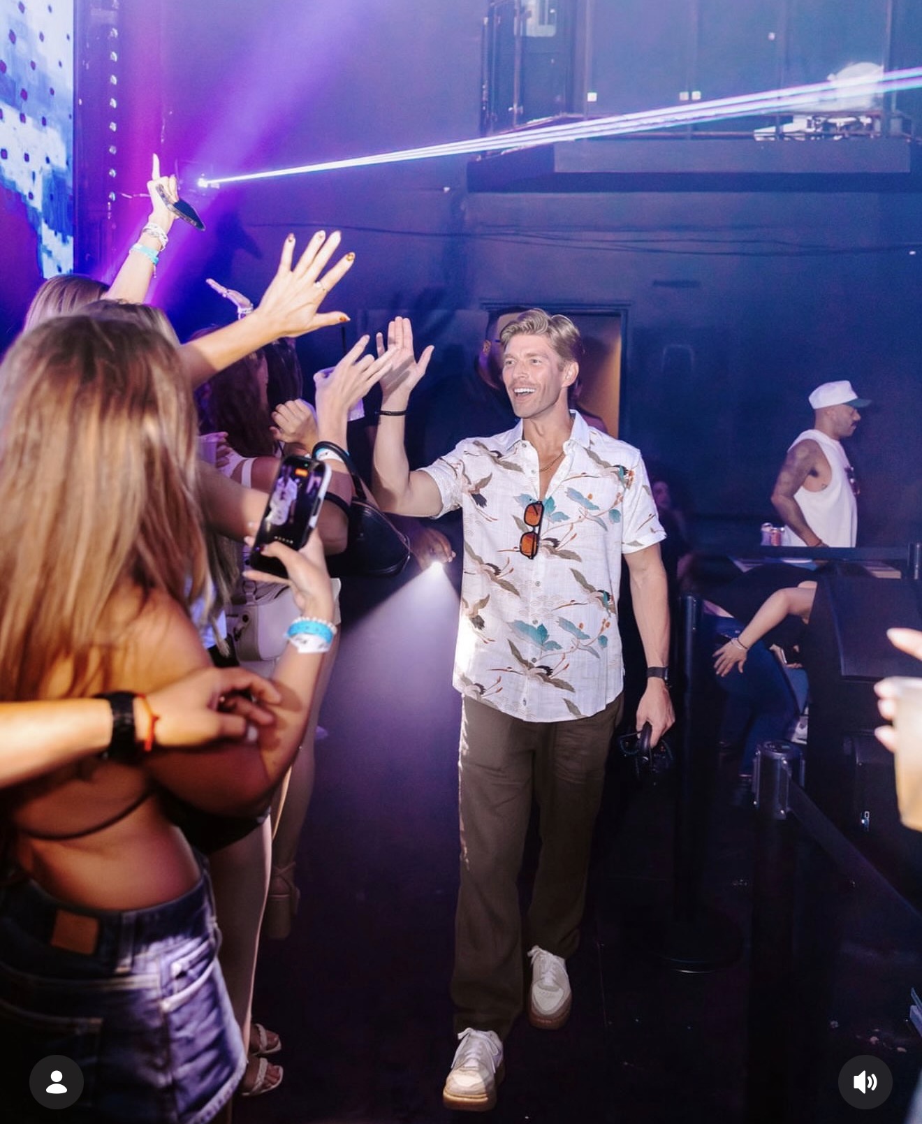 Talent greeting fans at a nightclub appearance in a printed camp shirt