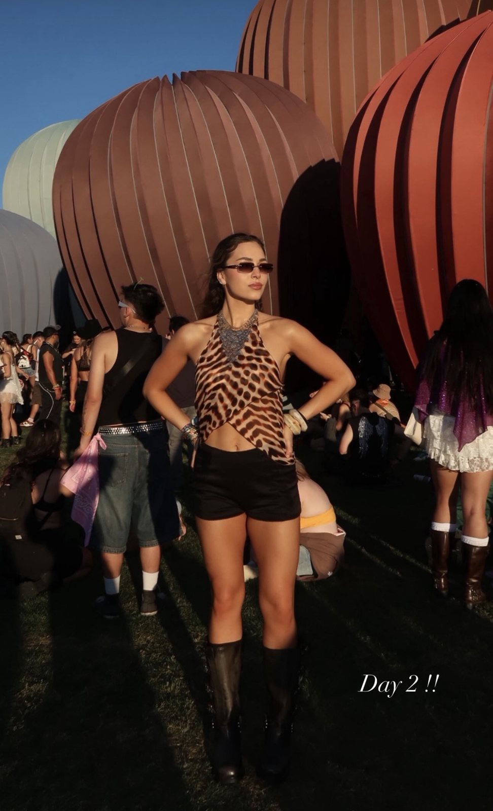 Client at Coachella day two in a leopard print halter top, black shorts, and boots